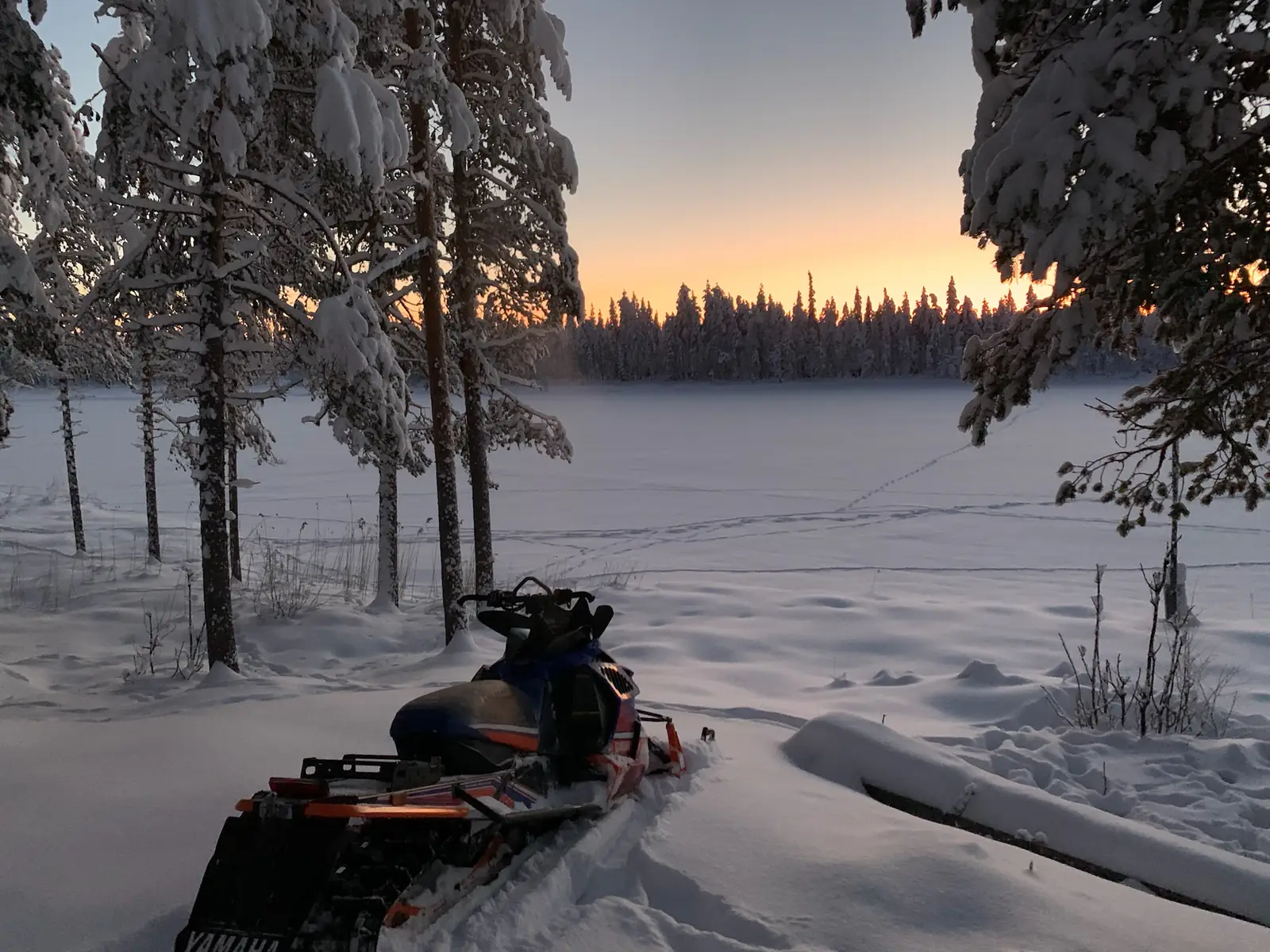 Snowmobile parked at a frozen lake