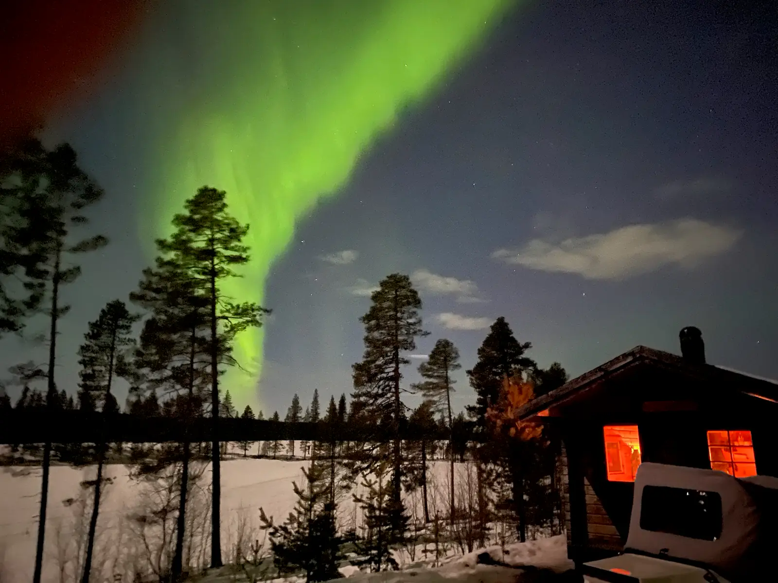 Aurora above the lakeside cabin